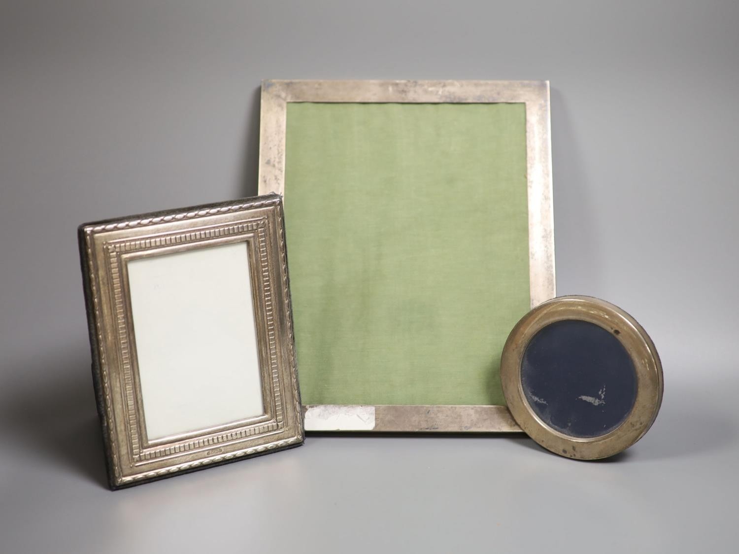 Three assorted silver mounted photograph frames, largest 27.3cm.